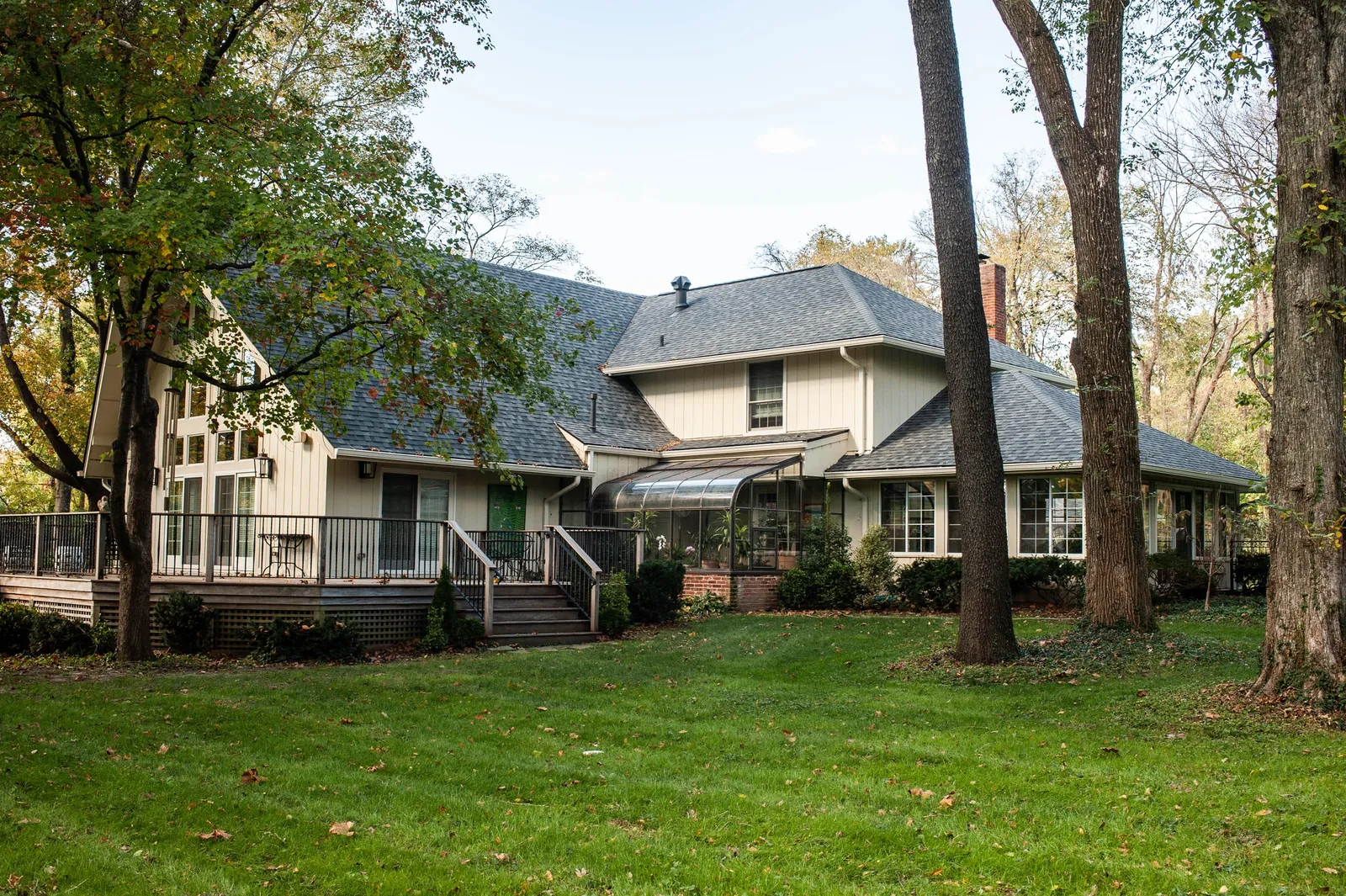 Shingle roof above a home's deck and glass garden enclosure